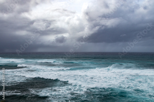 Dark storm clouds above rough waves in ominous seascape in the open ocean