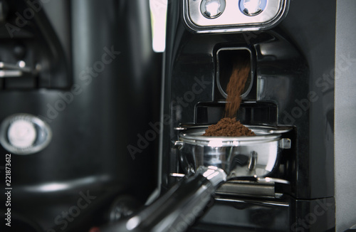 Barista using grinder machine for freshly roasted coffee bean make into a powder.