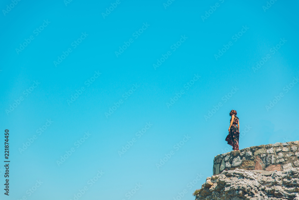 Fototapeta premium woman stand on the cliff in light dress at sunny day