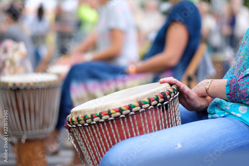 Hands of a musician playing on an African djembe drum, at a percussion music festival photo