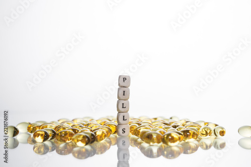 Word pills from the letters of cubes and Lecithin gel pills on light background. photo