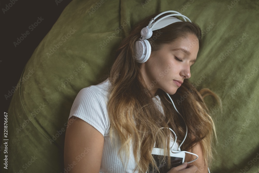 Woman listening music on headphones while sleeping Stock Photo