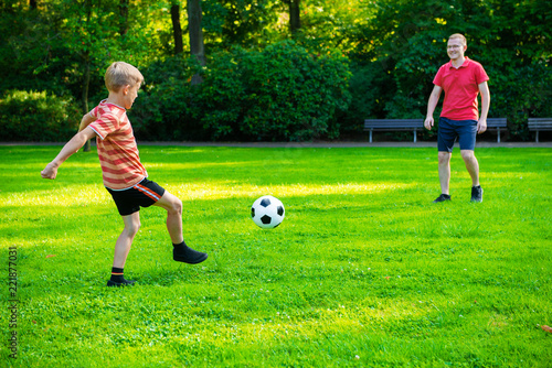 Happy young father play with his little son football in sunny park © spass