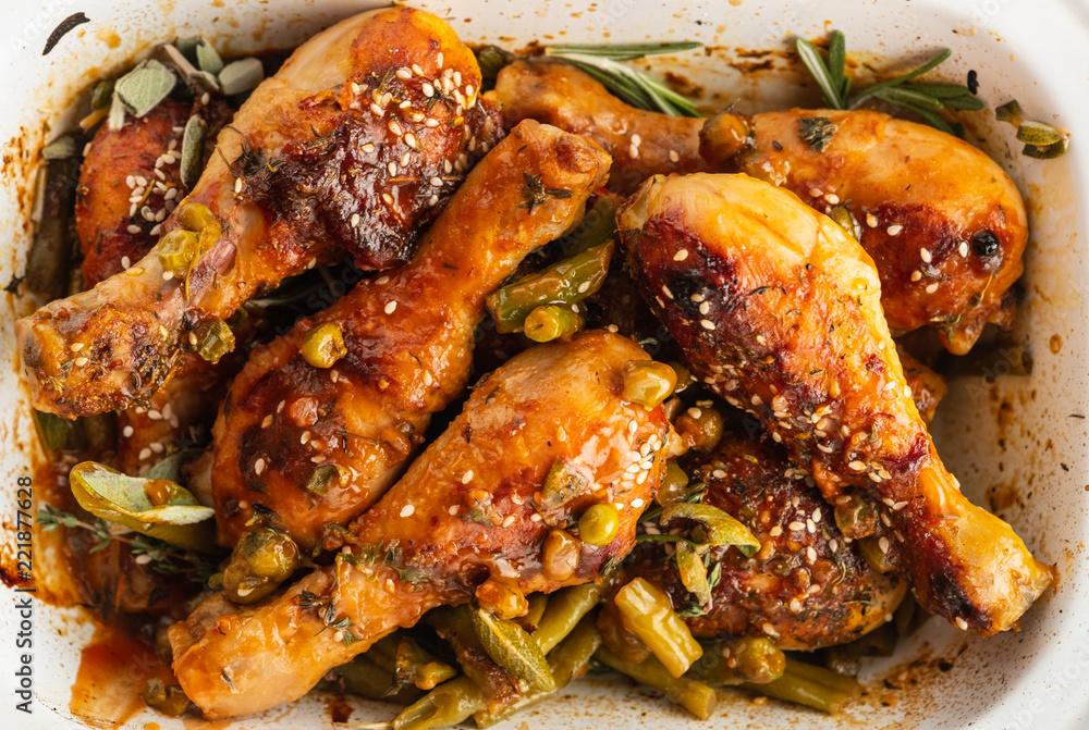 Baked chicken legs with peas, beans and fresh herbs. Chicken drumsticks with tasty sause and greens