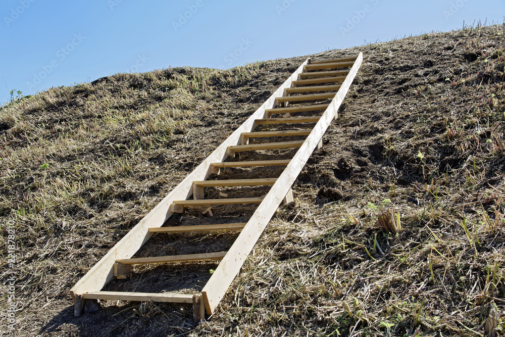 Wooden flooring lies on the hillside as a symbol of development, human movement