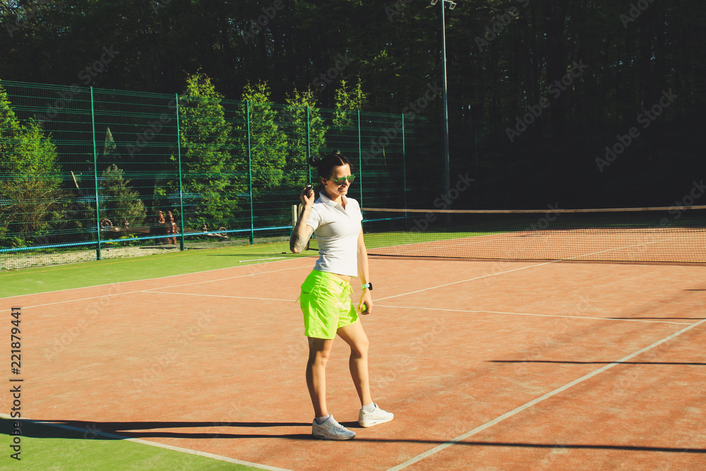 Portrait of girl with dart hair play tennis. Background tennis court.White t-shirt polo and yellow shorts.Sport shooting.