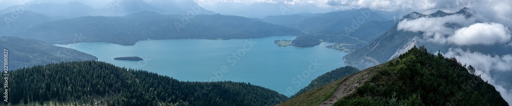Mountain panorama with lake and forest and clouds