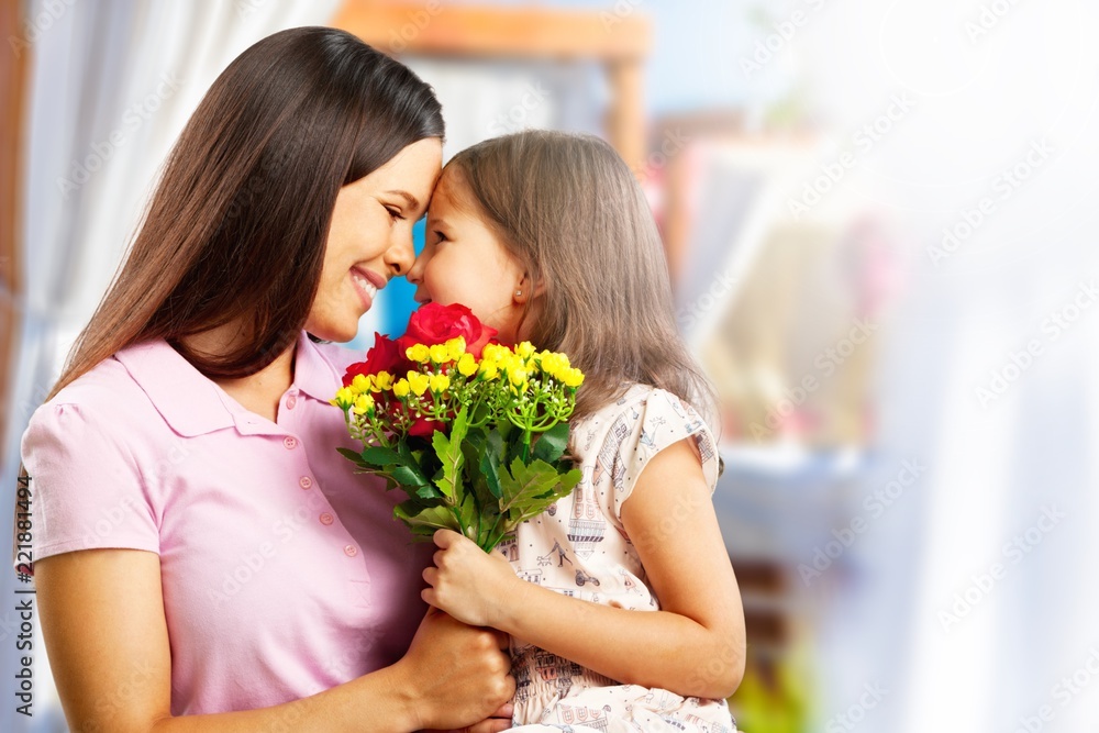 Portrait of happy mother and daughter holding flowers Portrait of happy mother and daughter holding flowers
