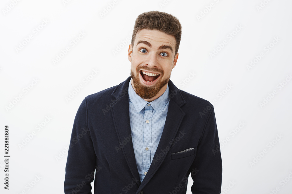 Waist-up shot of enthusiastic delighted and surprised charismatic young rich bachelor in stylish suit with beard and blue eyes smiling broadly from amazement and joy gazing impressed at camera Waist-up shot of enthusiastic delighted and surprised charismatic young rich bachelor in stylish suit with beard and blue eyes smiling broadly from amazement and joy gazing impressed at camera