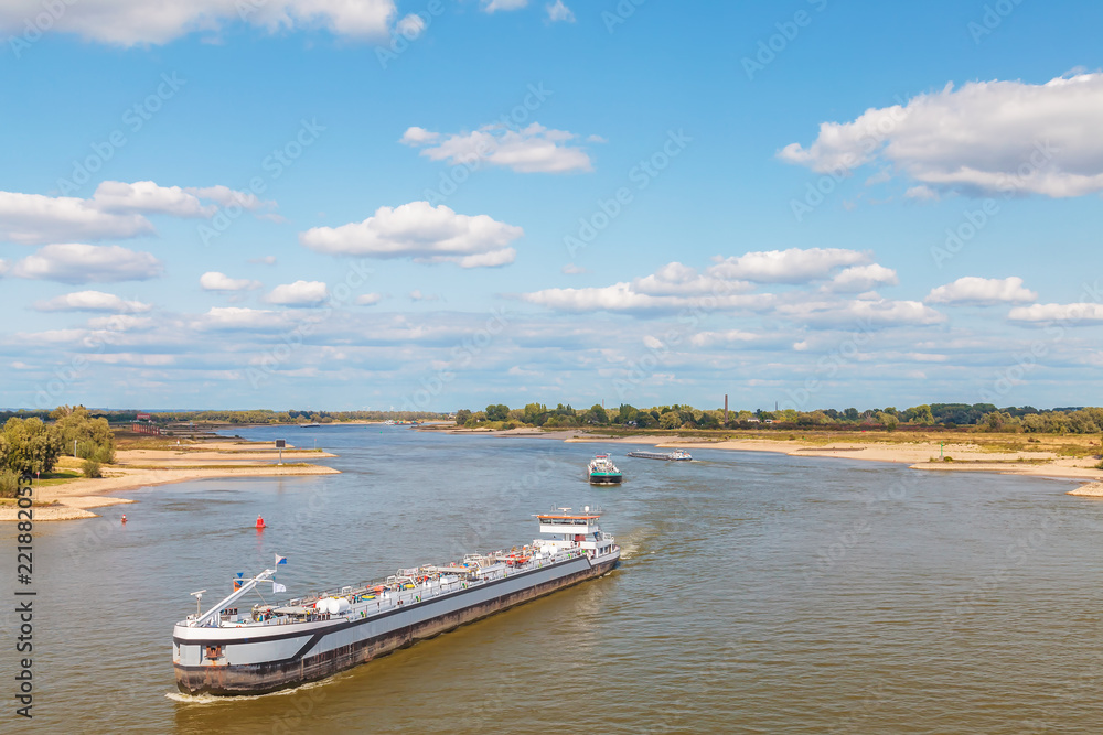 The Dutch Waal river near Nijmegen with cargo ships passing by