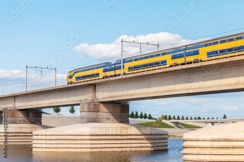 Dutch train crossing the sideskirts of the river Waal in front of Nijmegen