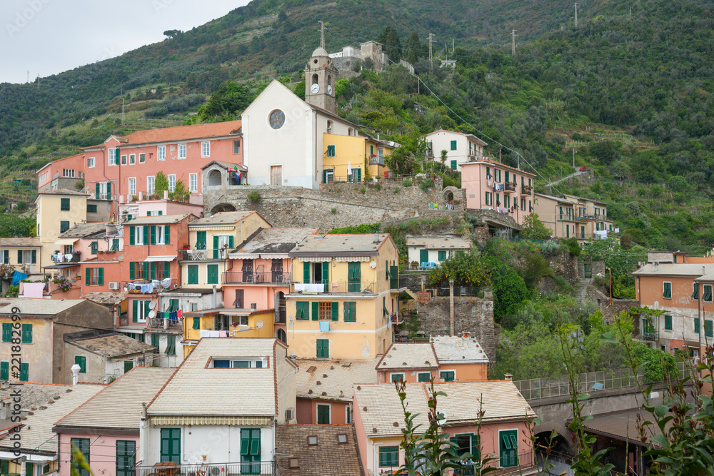 Obraz premium Church built on hillside overlooking traditional fishing village of Riomaggiore in Cinque Terre