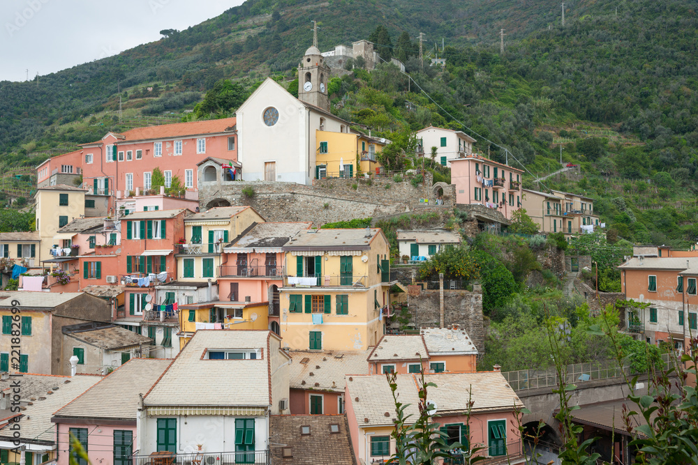 Church built on hillside overlooking traditional fishing village of Riomaggiore in Cinque Terre