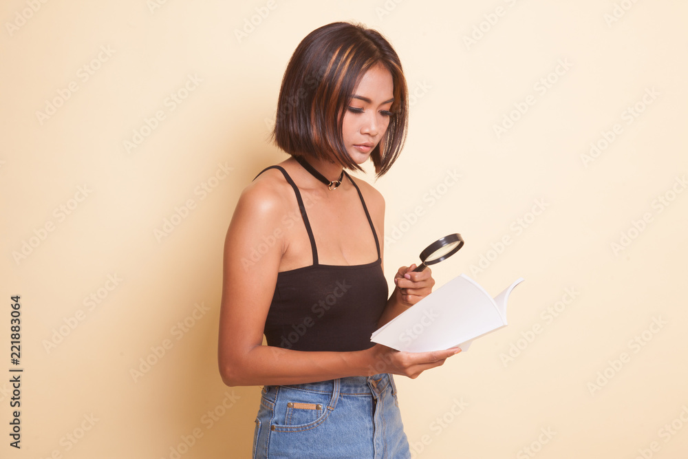 Asian woman with a book and magnifying glass. Asian woman with a book and magnifying glass.