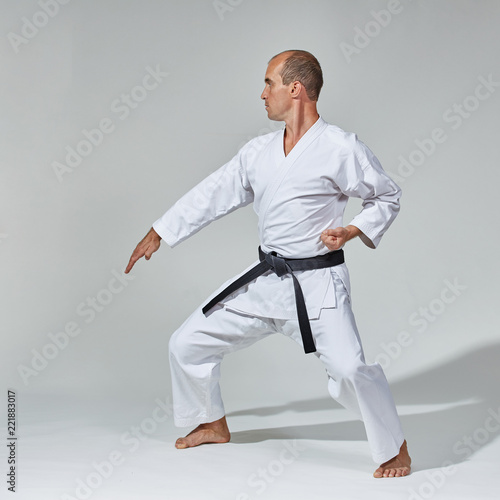 A young athlete with a black belt does formal karate exercises