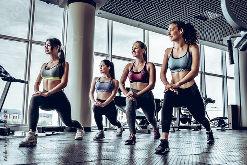 Four young sporty girl with athletic body doing fallouts in gym © HBS