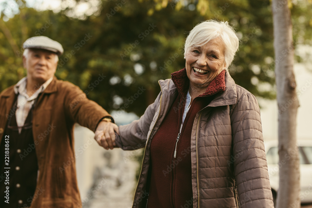 Happy senior couple walking outdoors on a winter day Happy senior couple walking outdoors on a winter day