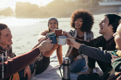 Photography Multi-ethnic friends toasting coffee mugs at the beach