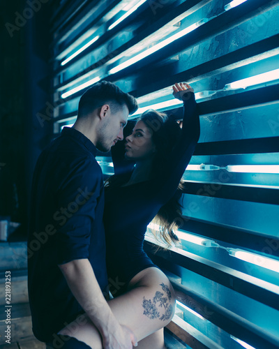 Beautiful young passionate couple is smiling and hugging before having sex in kitchen at home