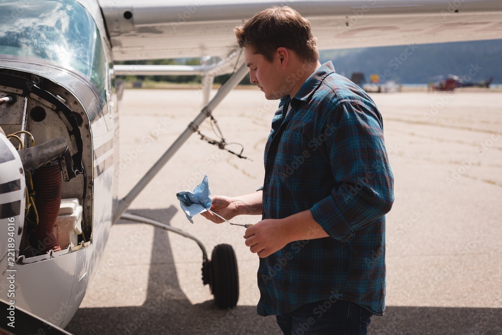 Engineer servicing aircraft engine near hangar Engineer servicing aircraft engine near hangar