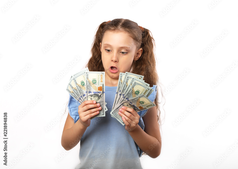 Happy kid girl holding money dollars with surprising emotion and opened mouth on white background with empty copy space Happy kid girl holding money dollars with surprising emotion and opened mouth on white background with empty copy space