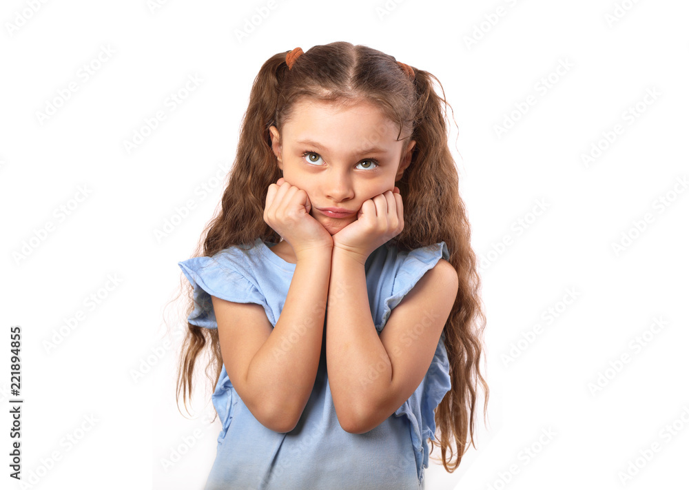 Beautiful small kid with pretty eyes dreaming about and looking up with hand under the face. Closeup portrait on white background with empty copy space Beautiful small kid with pretty eyes dreaming about and looking up with hand under the face. Closeup portrait on white background with empty copy space