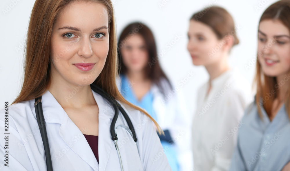 Young beautiful female doctor smiling while consulting her patient. Physician at work. Medicine and healthcare concept Young beautiful female doctor smiling while consulting her patient. Physician at work. Medicine and healthcare concept