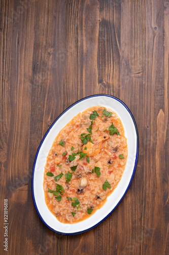 rice with seafood and herbs on white dish