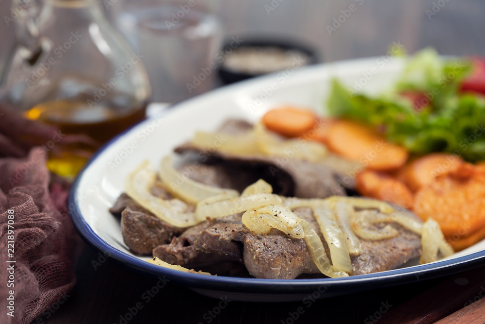 fried liver with onion, sweet potato and salad  on white dish