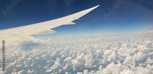 airplane wing with clouds