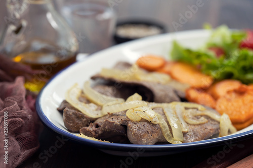 fried liver with onion, sweet potato and salad on white dish