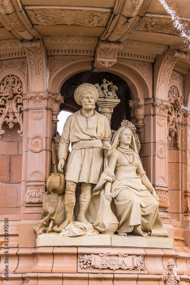 Glasgow, Scotland, UK - June 17, 2012: Doulton Fountain on Glasgow Green. Brown stone statues of couple in traditional garb depicting the colony India.