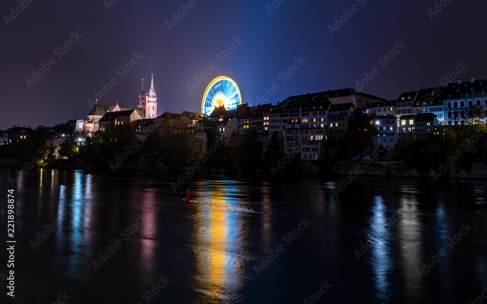 Riesenrad auf dem Münsterplatz neben dem Basler münster am Rhein mit lichtspiegelung im Wasser 