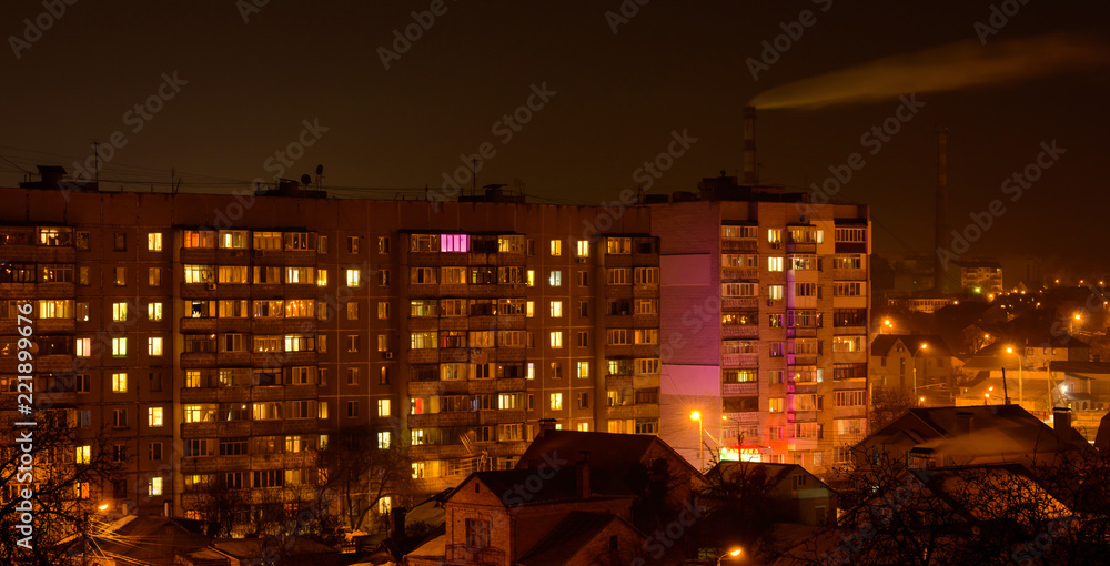 Photo of buildings at night with factory smoke above them Photo of buildings at night with factory smoke above them
