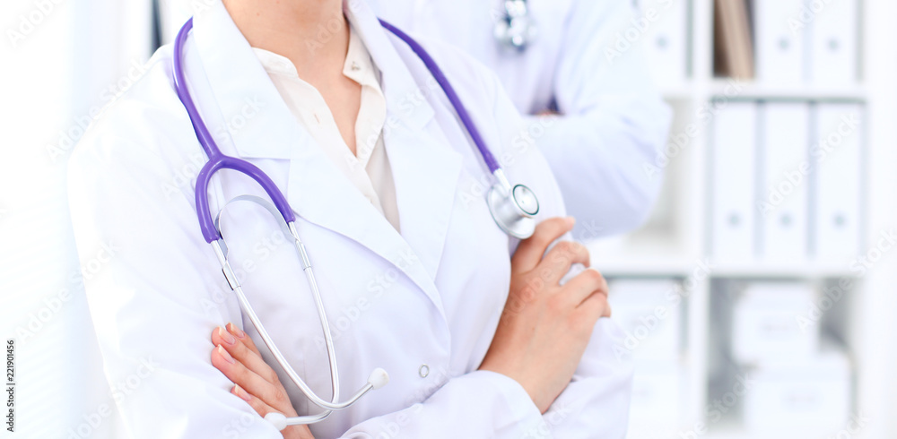 Unknown female doctor with medical staff at hospital. Teamwork in medicine Unknown female doctor with medical staff at hospital. Teamwork in medicine