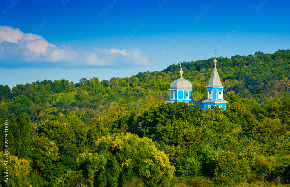 Photo of blue church between green trees