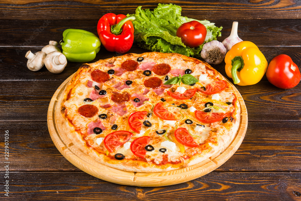2 kinds of pizza in one - salami, tomatoes, ham. Creative author's pizza.