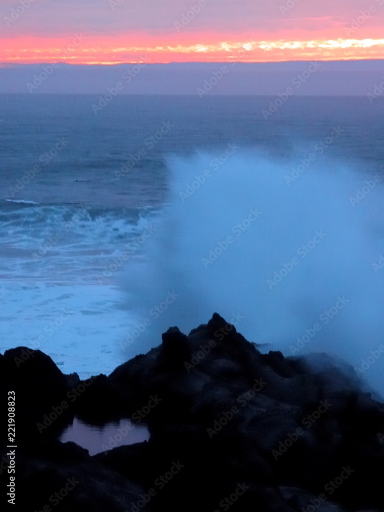 Thundering shores surf crashing on rocky shoreline at sunset Oregon coast