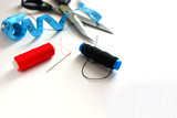 Sewing accessories thread, needle, scissors measuring tape for a weathered background, red and black thread