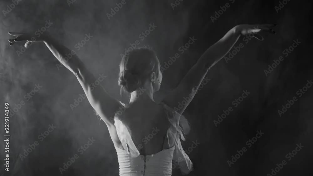 Professional ballerina dancing ballet in spotlights on big stage. Beautiful caucasian young girl wearing white tutu dress. Black and white vintage retro effect tonned Professional ballerina dancing ballet in spotlights on big stage. Beautiful caucasian young girl wearing white tutu dress. Black and white vintage retro effect tonned