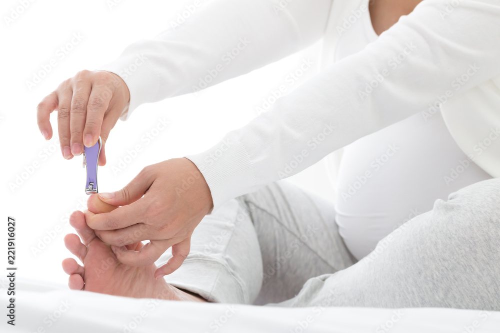 Pregnant women cutting foot nails, Are manicures safe during pregnancy concept Pregnant women cutting foot nails, Are manicures safe during pregnancy concept