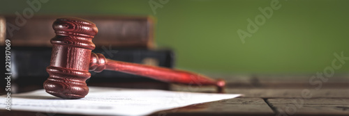 Wooden gavel and books on wooden table, law concept photo