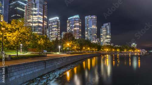 Long exposure of Downtown Vancouver on a dramatic sky after a rain. Beautiful city mirroring in the pacific shore. British Columbia, Canada. © Daniel Avram