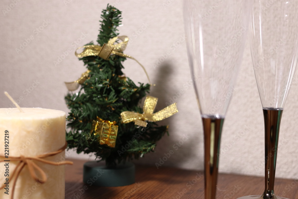 テーブルの上の2つのシャンパングラスとクリスマスツリーとキャンドル テーブルの上の2つのシャンパングラスとクリスマスツリーとキャンドル