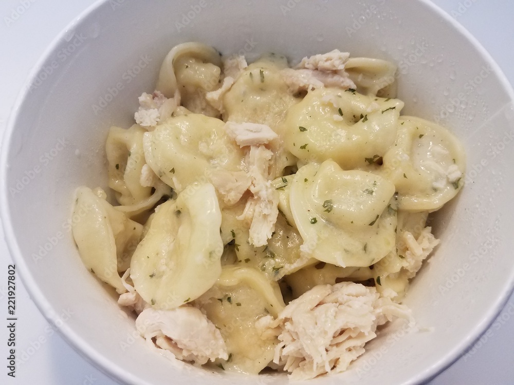 tortellini pasta with cheese and sauce with chicken in white bowl