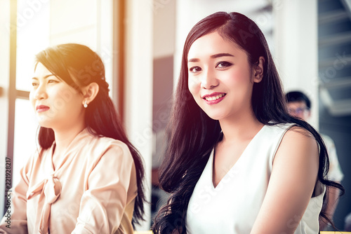 Pretty young businesswoman is smiling in meeting with her colleagues