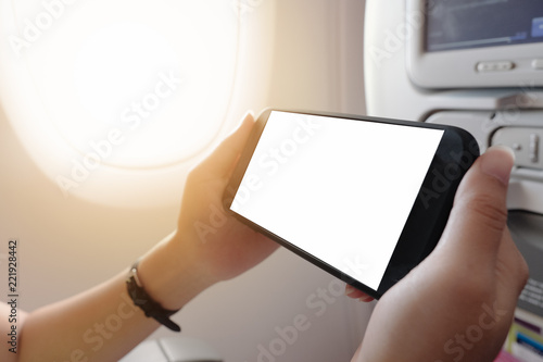 touching and slide mobile phone screen on airplane or aircraft,blank mobile phone screen mock up,selective focus