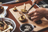 Hands cut raw mushrooms with sharp knife