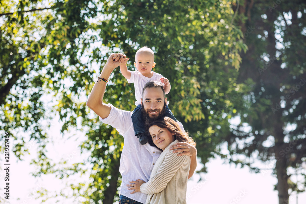 Family mom dad and baby happy with smiles together outdoors in the Park summer portrait Family mom dad and baby happy with smiles together outdoors in the Park summer portrait