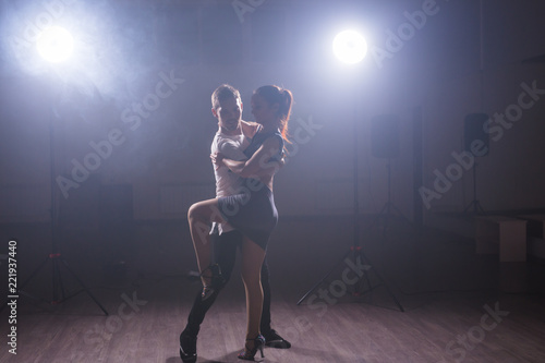 Young couple dancing social danse kizomba or bachata or semba or taraxia in dancing class background